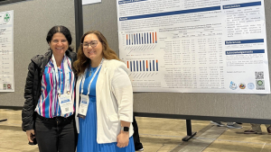 two people standing in front of a poster board