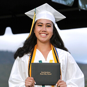 Rodrigues in cap and gown holding diploma