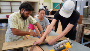 students cutting a wood board